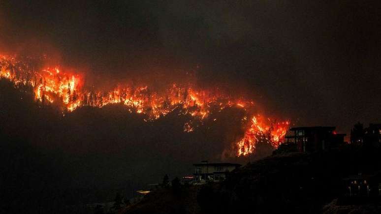 Fumaça e chamas dos incêndios florestais avançam ao longo do lago Okanagan, em West Kelowna, na província de British Columbia