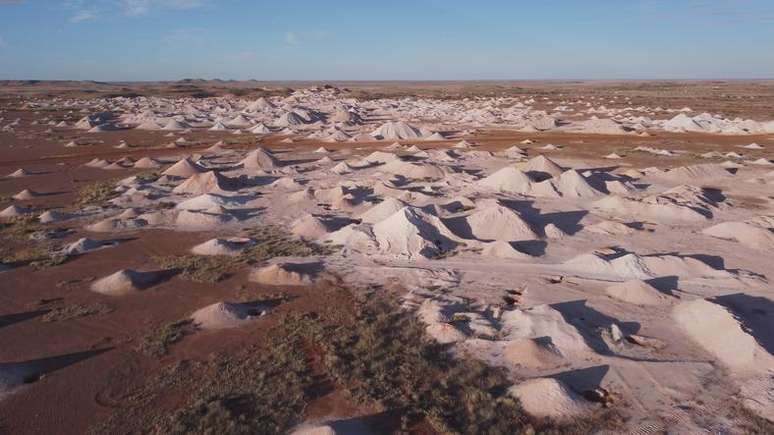 Andar a pé no deserto perto de Coober Pedy pode ser perigoso. O terreno é salpicado de poços de mineração abandonados