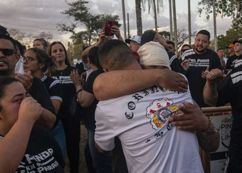 Torcedores do Corinthians e familiares de mortos em acidente se abra&ccedil;am antes do in&iacute;cio do vel&oacute;rio.