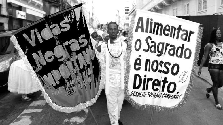 Imagem em preto e branco mostra um homem negro no carnaval de rua de Salvador.