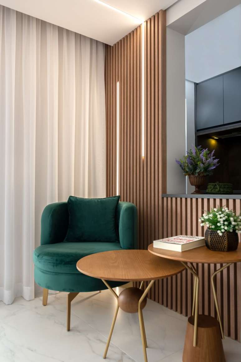 Palladino Architecture project.  In the photo, living room with slatted wall illuminated with LED strips and green armchair.