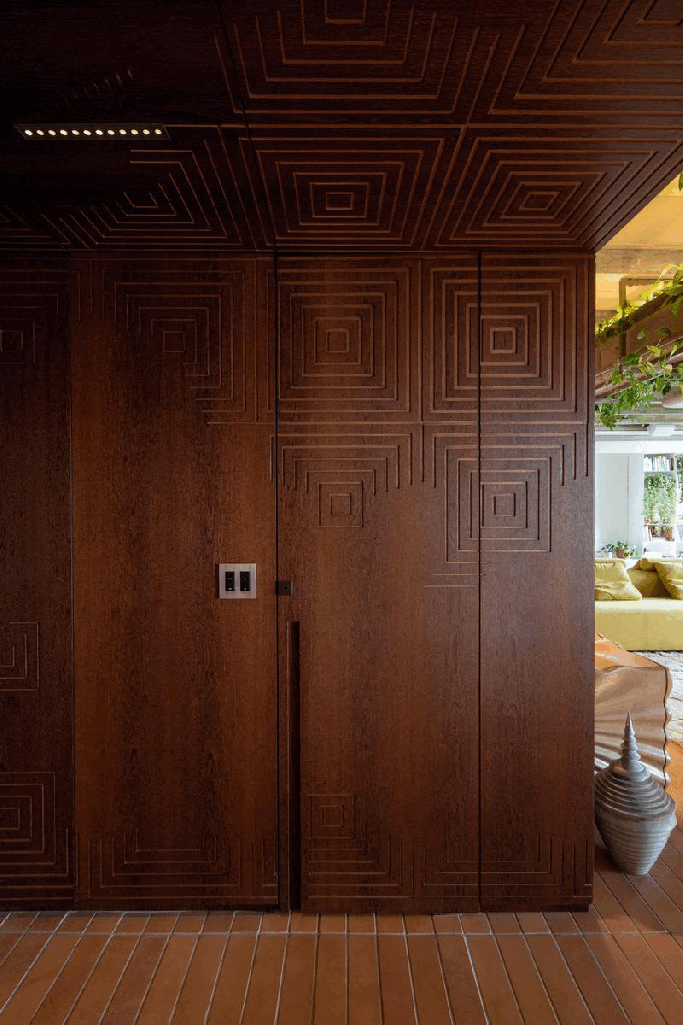 Project by Estudio Guto Requena.  In the photo, a gif showing the wooden panel that camouflages the bathroom door