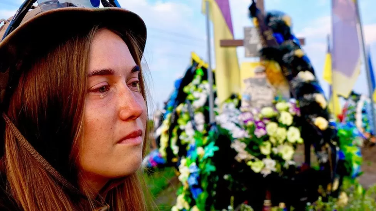 Oksana chora ao lado do t&uacute;mulo de seu marido, que morreu em novembro