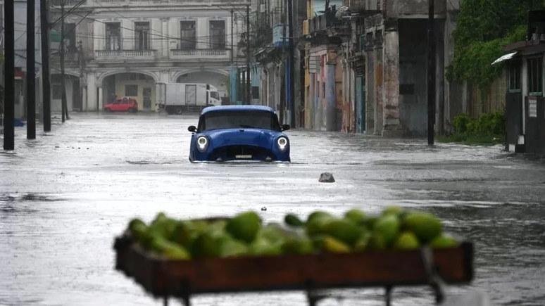 Um velho carro americano passa por uma rua alagada em Havana, no dia 29 de agosto de 2023, durante a passagem do Idalia