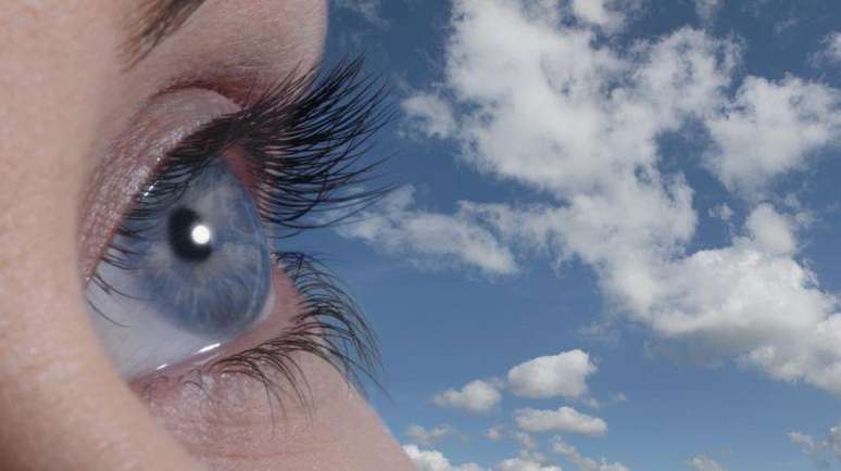 olhos azuis com céu azul atrás