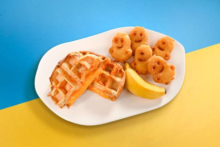 O combo de café da manhã serve um waffle de queijo, banana e batatas fritas em formato de Minion