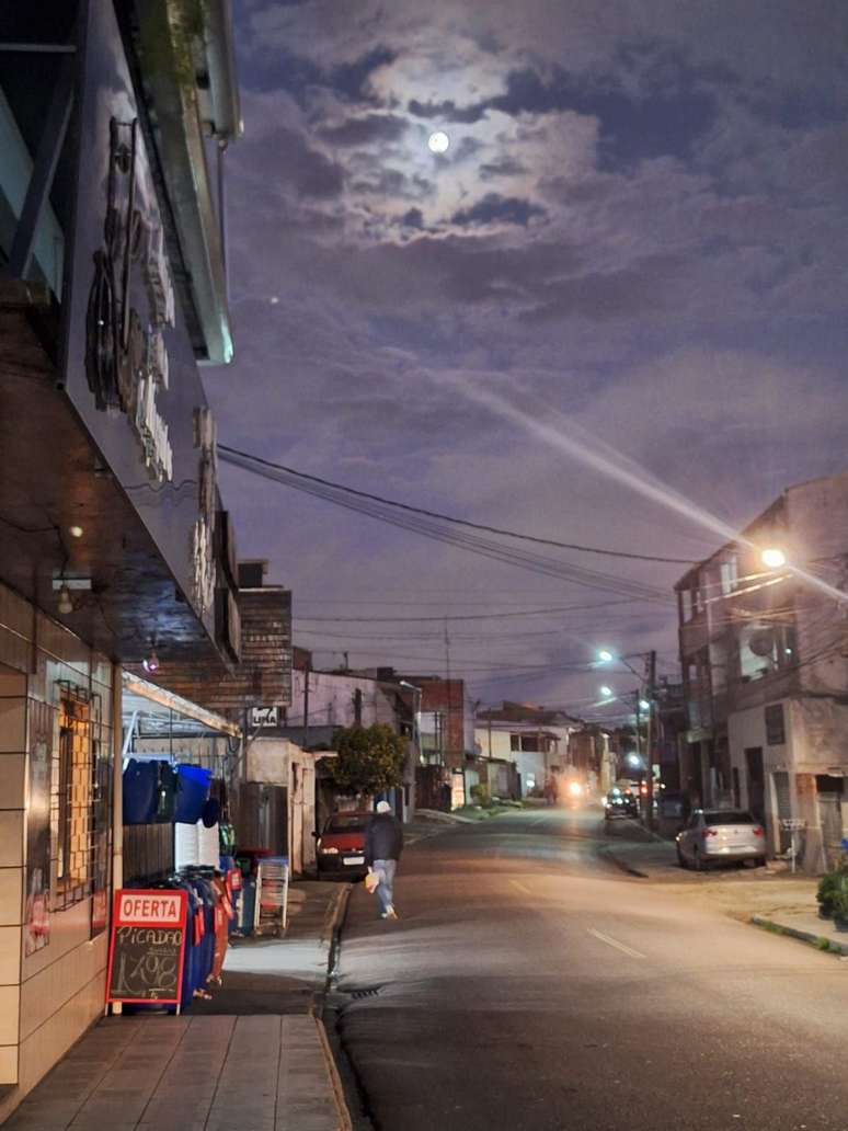 À noite, as luzes dos comércios abertos substituem a falta de iluminação pública na Vila Formosa, em Curitiba