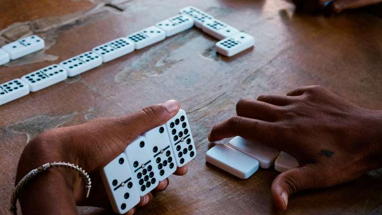 Conjunto de jogos de mesa, amigos jogando dominó e xadrez, um