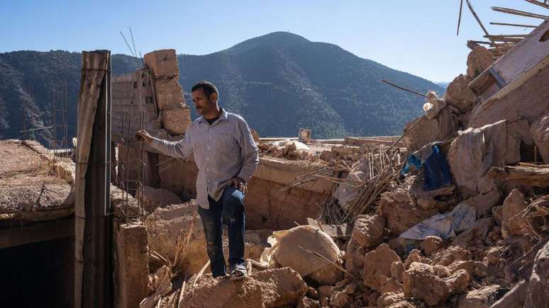 Homem em meio a ruínas de sua casa em Moulay Brahim
