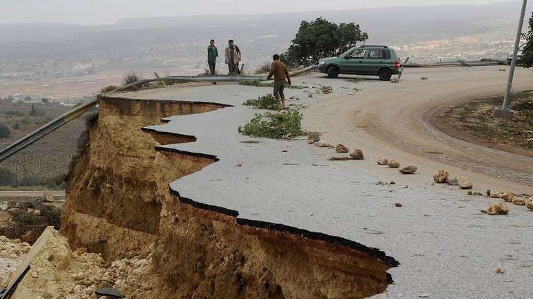 Motoristas em estrada danificada pela chuva na cidade de Shahhat, na Líbia