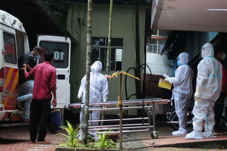 Profissionais transferem pessoas que estiveram em contato com uma pessoa infectada com o vírus Nipah para um hospital em Calecute