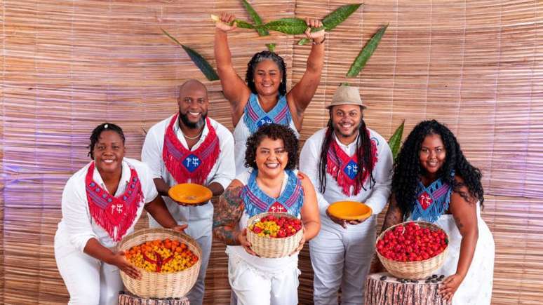 Integrantes do grupo Samba pra Rua seguram vasilhames com pimentas e uma espada de são jorge.