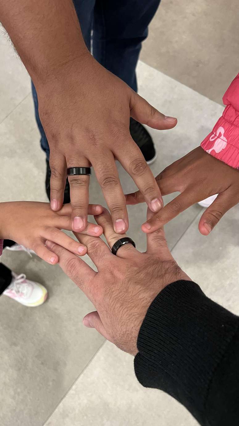 Família unida: mãos do jornalista Danilo Costa, do namorado, e das duas irmãs que ele adotou há menos de um mês