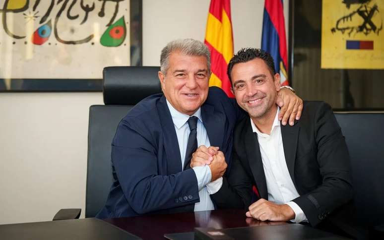 Xavi assinou o contato ao lado do presidente Joan Laporta –