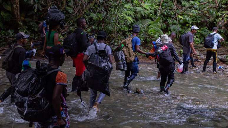 Os migrantes que atravessam a perigosa selva de Darien atravessam rios e enfrentam ameaças de grupos armados.