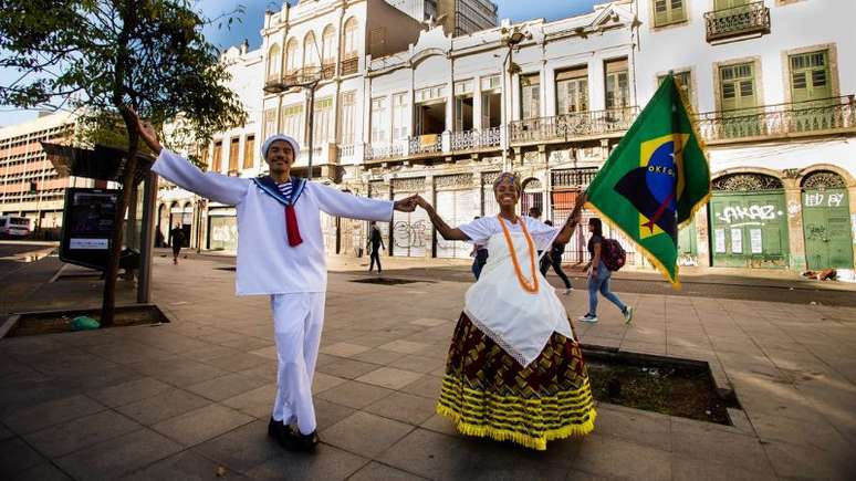 Imagem mostra casal de mestre-sala e porta-bandeira posando no centro histórico do Rio de Janeiro