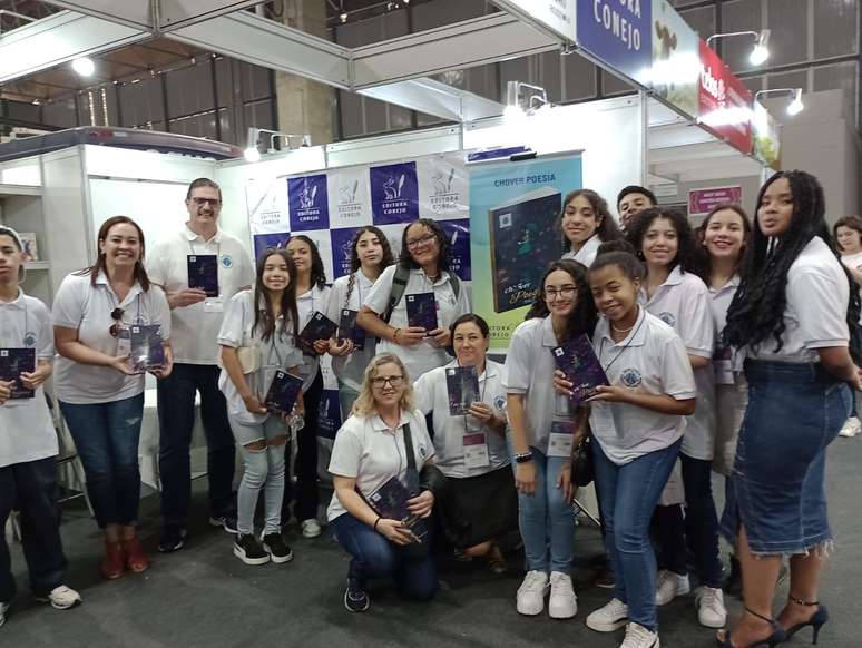 Grupo de estudantes com o professor Alexandre e a diretora Valquíria no estande da Editora Conejo na Bienal do Rio de Janeiro 