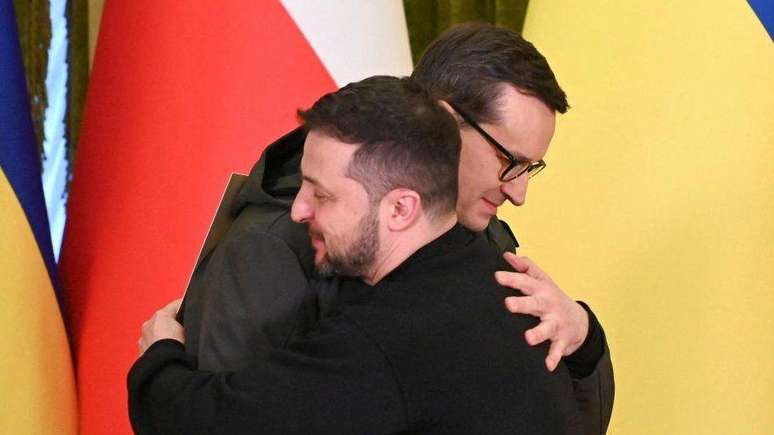 O primeiro-ministro da Pol&ocirc;nia, Mateusz Morawiecki, e o presidente ucraniano, Volodymyr Zelensky, se abra&ccedil;am em foto do in&iacute;cio do ano
