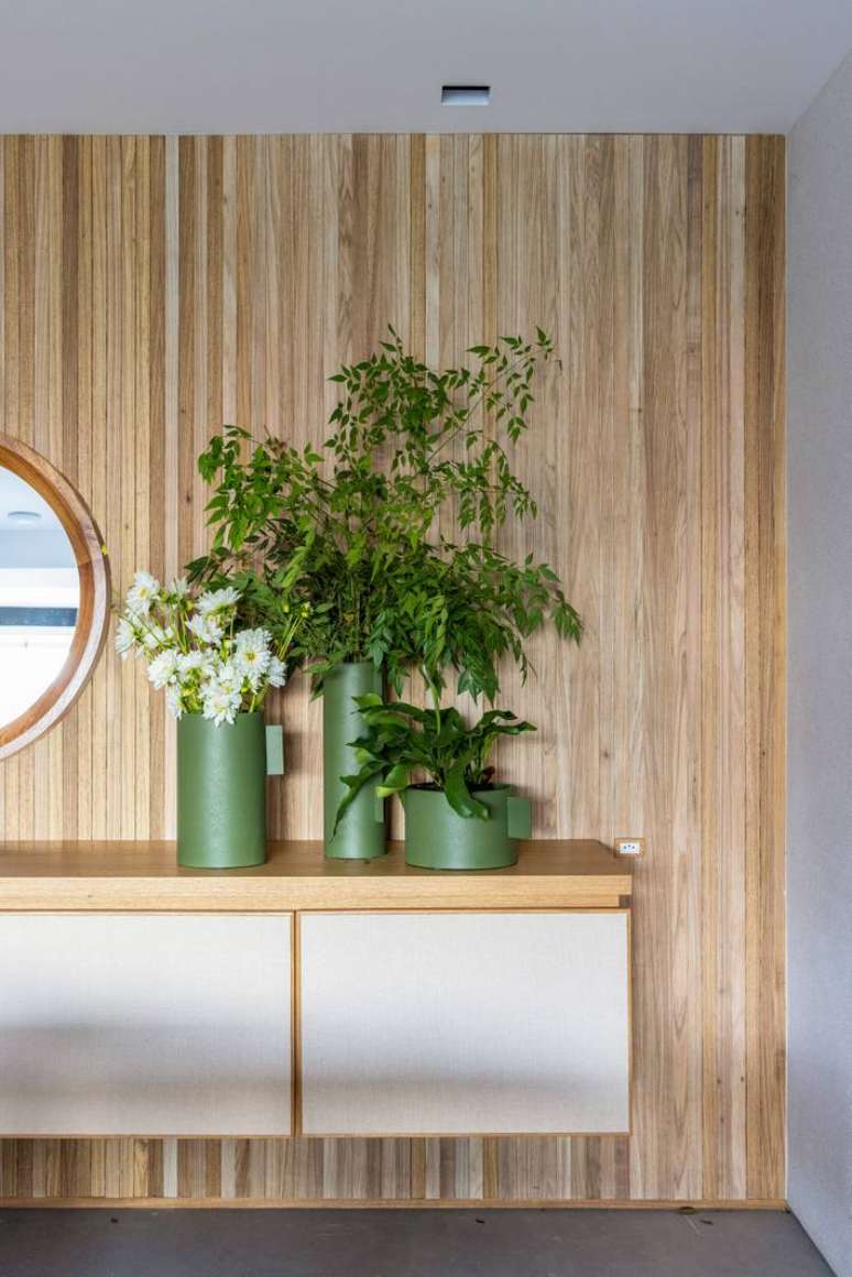 Hall de entrada com flores da esta&ccedil;&atilde;o no Projeto Escala Arquitetura.