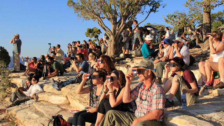 Pessoas acompanhando eclipse solar com óculos apropriados (Imagem: Reprodução/National Park Service)