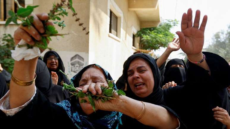 Pessoas em luto durante o funeral dos bebês gêmeos palestinos Ossayd e Mohammad Abu Hmaid, a mãe e as três irmãs deles. Autoridades locais disseram que a família foi morta durante os ataques israelenses na Faixa de Gaza