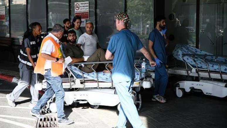 M&eacute;dicos empurram um homem ferido na entrada de emerg&ecirc;ncia do hospital Ichilov, em Tel Aviv, ap&oacute;s uma incurs&atilde;o do Hamas nos assentamentos israelenses ao redor da Faixa de Gaza