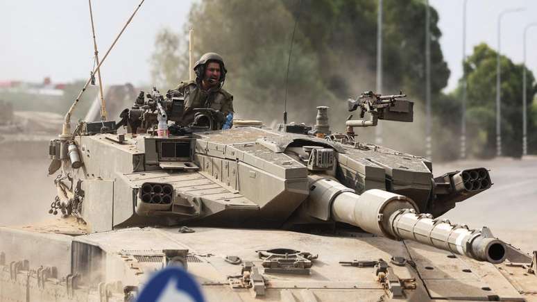 Soldados israelenses dirigem um tanque na fronteira de Israel com Gaza, no sul do pa&iacute;s