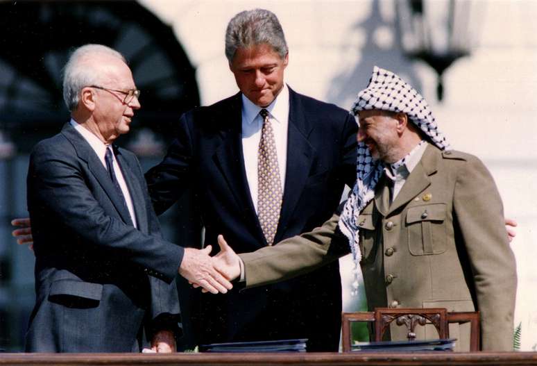 Foto histórica de 1993 marca o aperto de mão entre os líderes Yitzhak Rabin (à esq) e Yasser Arafat, com mediação do presidente americano Bill Clinton