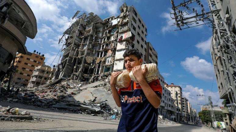 Um jovem palestino carregando pão na Cidade de Gaza