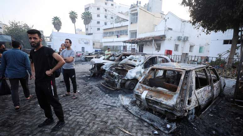 Pessoas observam os danos causados por explosão no hospital Al-Ahli em Gaza