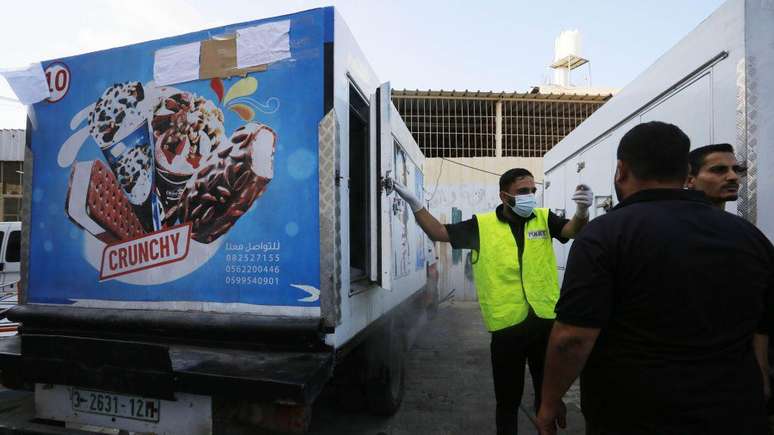 Policial usa caminhão de sorvete para colocar corpos no Hospital dos Mártires de Al Aqsa, na Faixa de Gaza