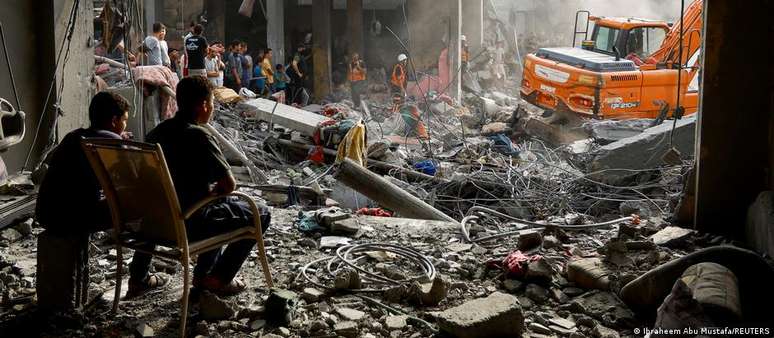 Palestinos no sul da Faixa de Gaza, em meio à destruição provocada pelos bombardeios israelenses
