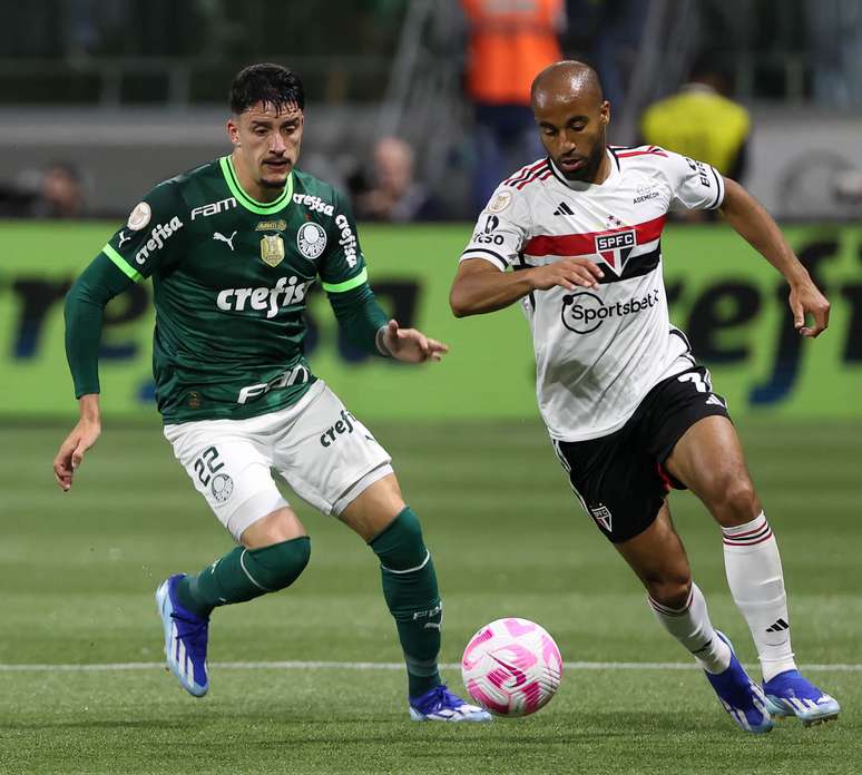 Perto da bola de futebol no campo verde  os jogadores vão jogar juntos