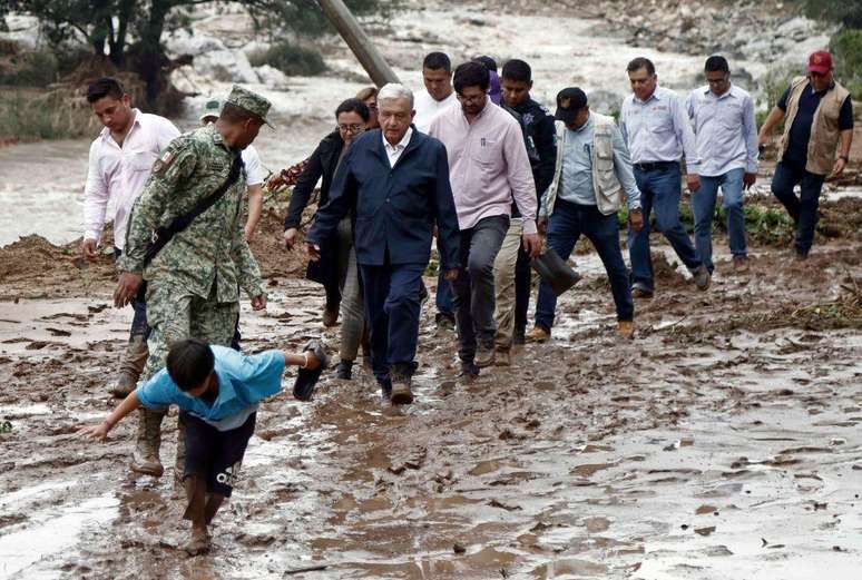 O presidente López Obrador teve que caminhar em lama para chegar a Acapulco