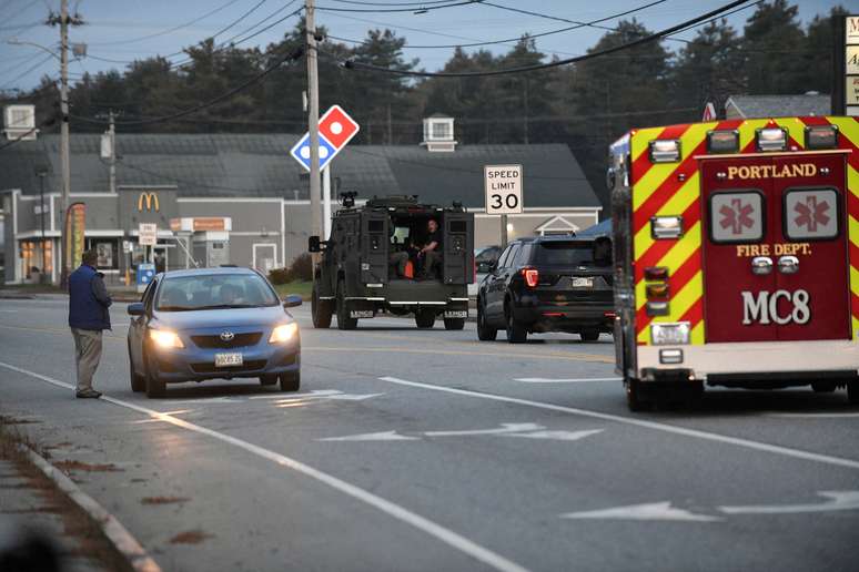 A polícia, posicionada em uma escola, sai da área enquanto uma busca ativa pelo atirador no Maine, EUA.