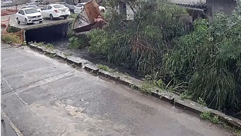 An elderly woman is carried away by the current after a house collapses during flooding in Rio