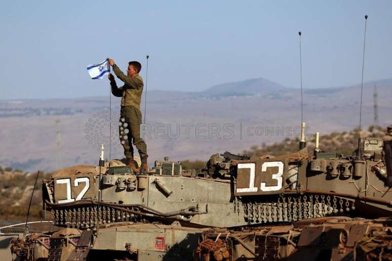 Soldado instala uma bandeira israelense em tanque durante exercício militar perto da fronteira com o Líbano, no norte de Israel
26/10/2023
REUTERS/Lisi Niesner