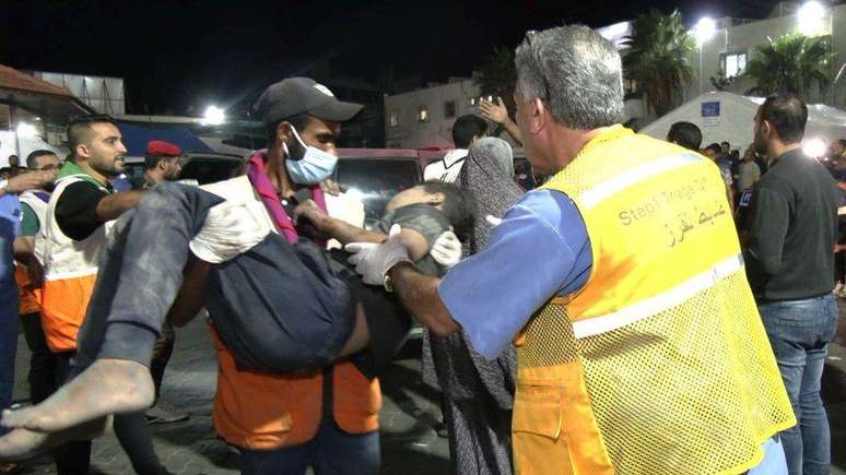 Paramédico leva criança para hospital após ataque aéreo à igreja