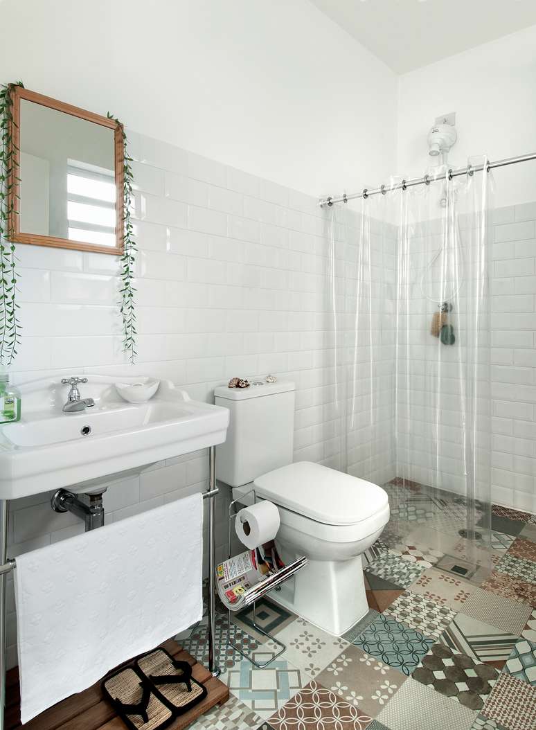 O ar antiguinho deste projeto foi conquistado graças ao casamento do porcelanato com aparência de ladrilho hidráulico no piso (similar: Oxford Deco, da Biancogres, de 60 x 60 cm) com os subway tiles – os famosos azulejos das estações de metrô europeias – (modelo Metro White, da Eliane, de 20 x 10 cm), que cobrem todas as paredes até a altura de 1,80 m. A cortina de plástico transparente protege a área seca dos respingos e garante que a composição fique à mostra.