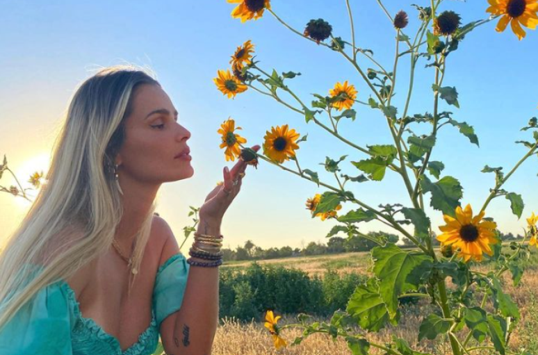 Yasmin Brunet e um campo rodeada de flores e girassóis. 