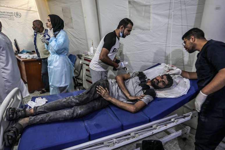 Homem palestino recebe atendimento médico no Hospital Al-Najjar, em Gaza, após ataque israelense.