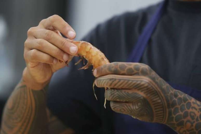 Chefe de cozinha exibe um camarão