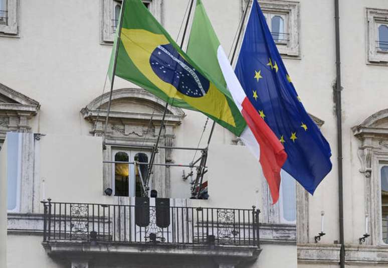 Bandeiras de Brasil, Itália e União Europeia no Palácio Chigi, sede do governo italiano, durante visita de Lula a Roma