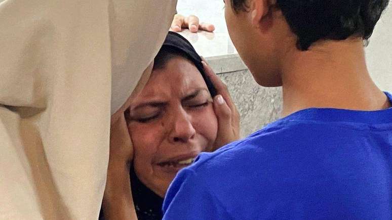 Uma mãe é consolada por seu filho no Hospital Al-Shifa depois que outro de seus filhos foi morto em um ataque aéreo israelense