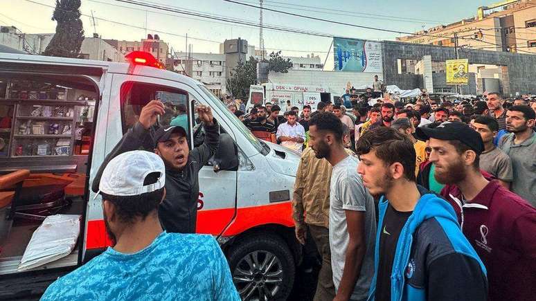 Pessoas se reúnem em torno de uma ambulância danificada em um suposto ataque israelense em frente ao hospital Al-Shifa, na cidade de Gaza, em 3 de novembro