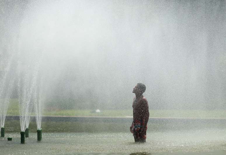 Homem se refresca em fonte durante onda de calor no Rio de Janeiro 