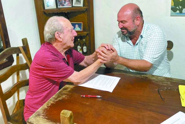 André Fernandes, fundador e diretor da Agência de Notícias das Favelas (ANF), assina contrato para Casa da Favela com Carlos Conti, proprietário do casarão onde reside há mais de 30 anos