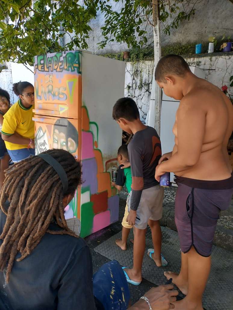 Geladeiras velhas são pintadas na rua do Morro, onde os jovens e a população podem fazer troca de livros doados
