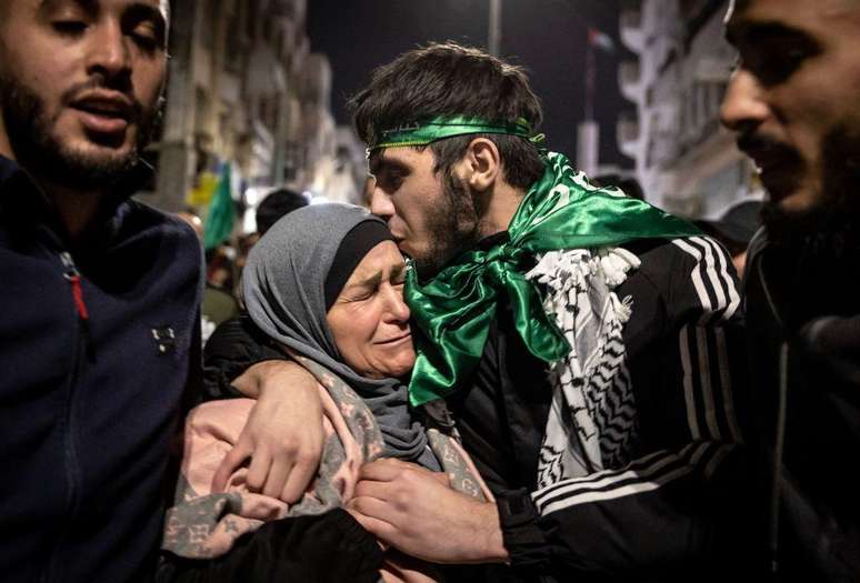 Um prisioneiro palestino abraça sua mãe após ser libertado de uma prisão israelense em troca de reféns israelenses libertados pelo Hamas da Faixa de Gaza, em Ramallah, na Cisjordânia ocupada, em 26 de novembro de 2023