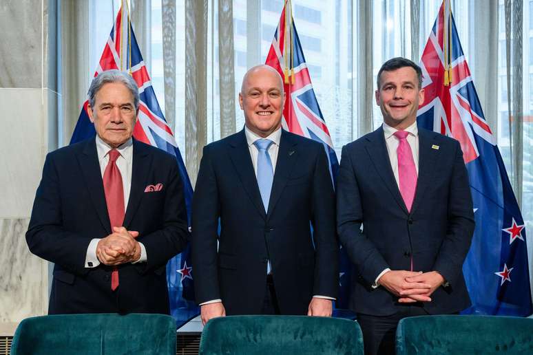 O novo governo de coalizão é composto pelo partido Nacional do primeiro-ministro Chris Luxon (centro) e seus parceiros Winston Peters (esquerda), líder do partido New Zealand First, e David Seymour (direita), líder do partido Act